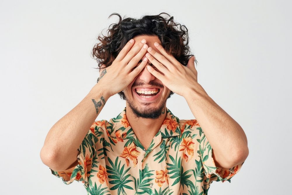 Young male covering eyes with hands smiling cheerful and funny laughing person tattoo.