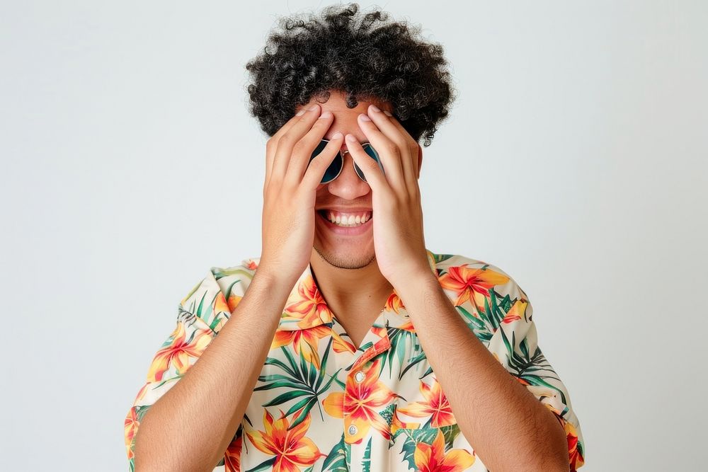 Young male covering eyes with hands smiling cheerful and funny photo accessories photography.