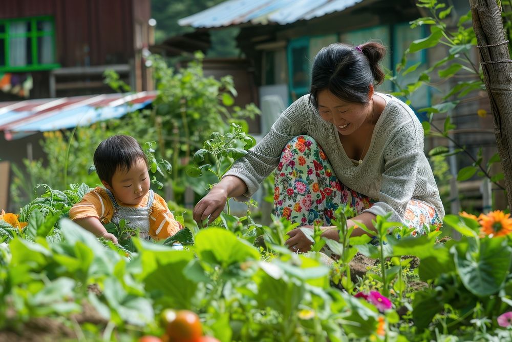 A woman and child tending the garden gardening outdoors nature.