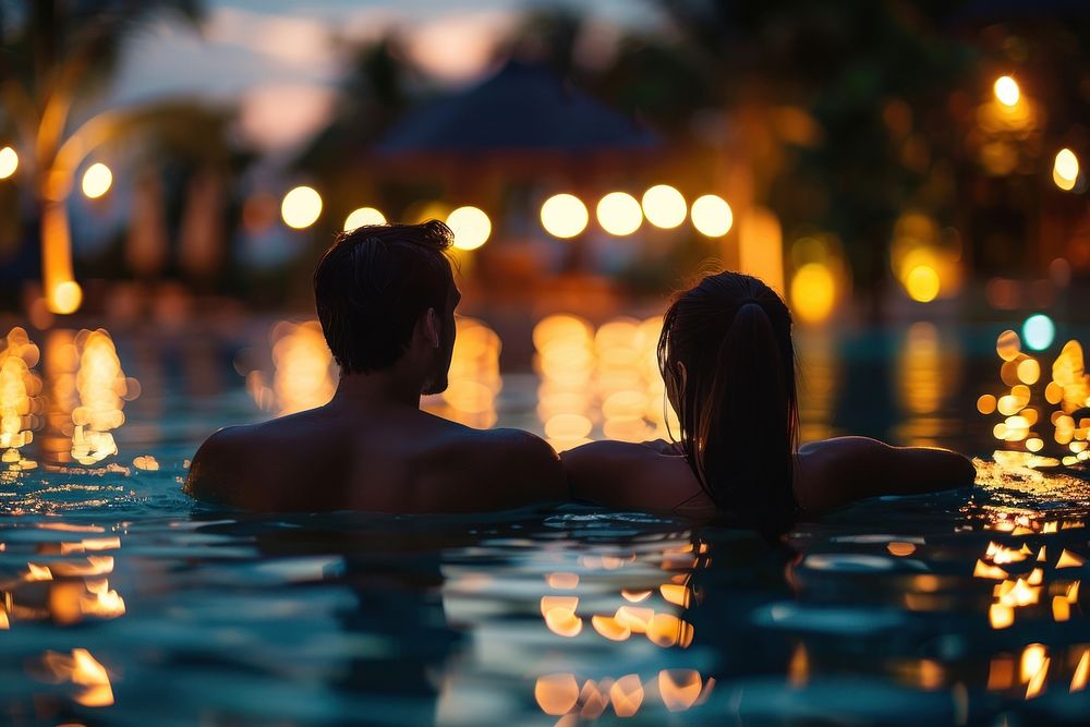 Young couple traveler relaxing and enjoying a tropical resort pool back architecture recreation.
