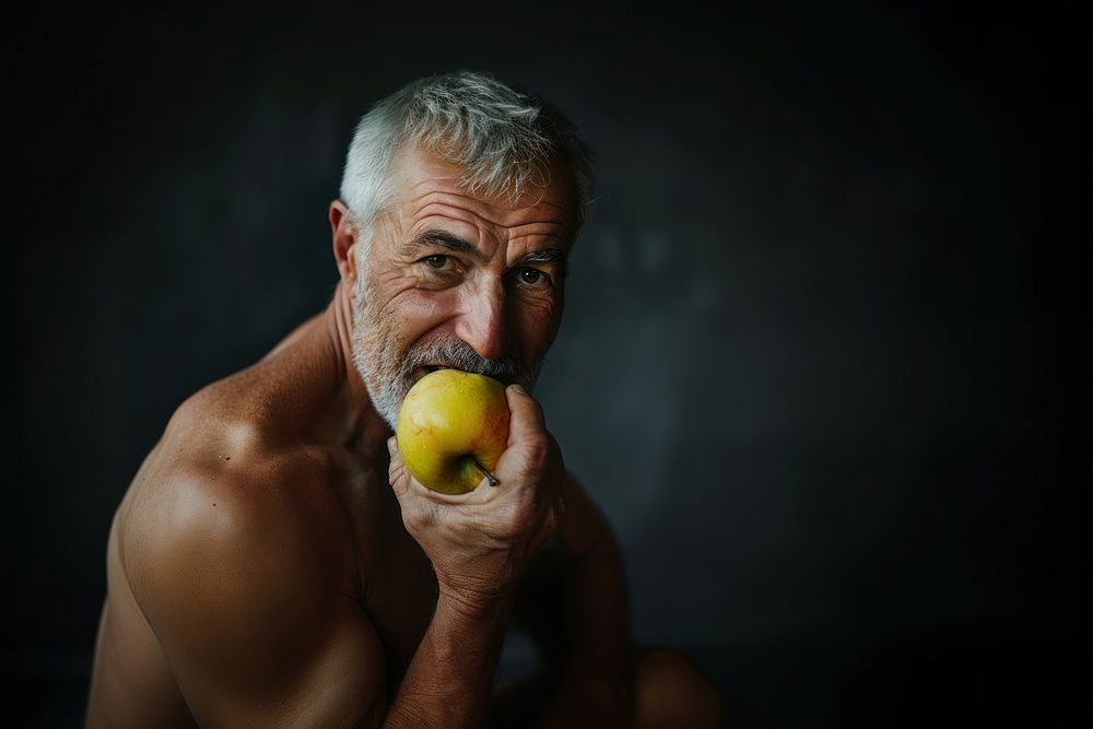 Healthy elder muscle man eating produce biting.