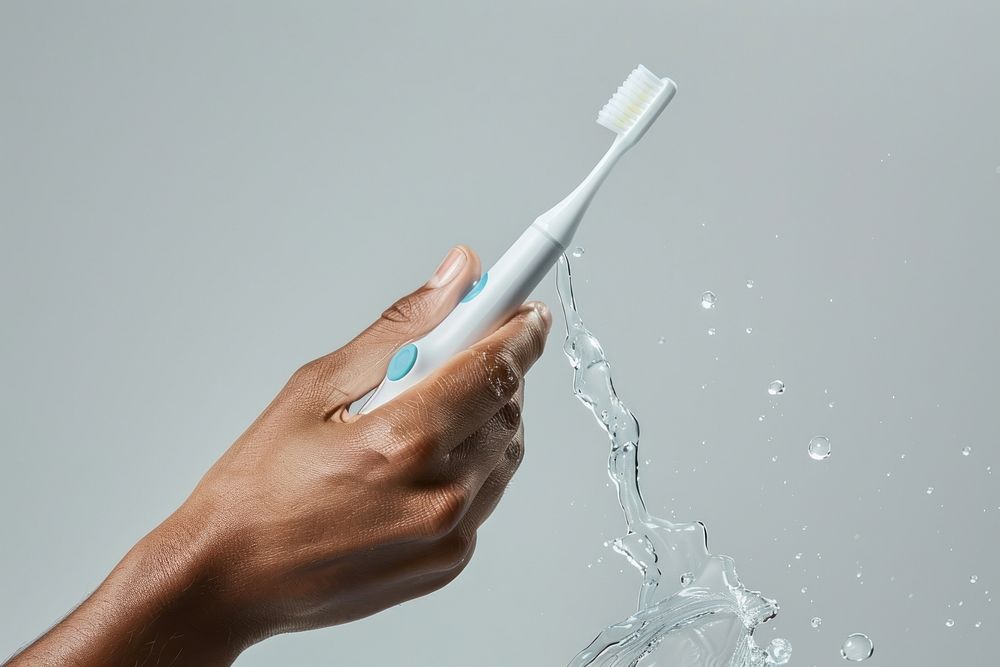Hand with toothbrush splashing hygiene holding.