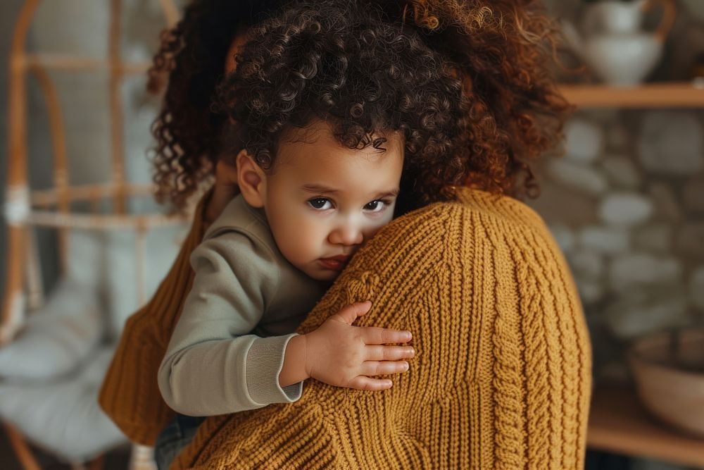 Caring biracial mother hold lean to chest cute little infant toddler clothing knitwear apparel.