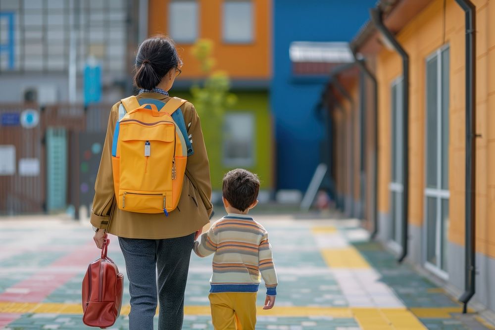 Mother entering the kindergarten yard boy pedestrian backpack.