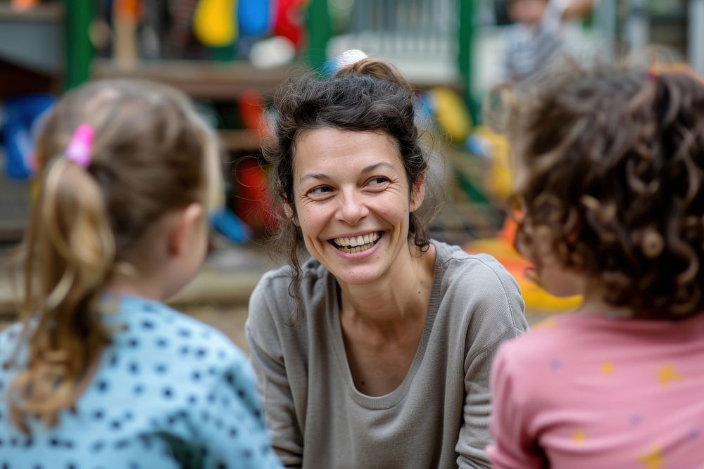 Middle age woman preschool teacher happy kid laughing.
