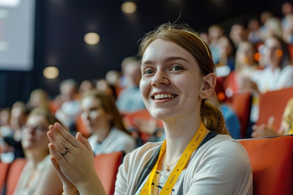 Young Female Sitting in a Crowded Audience at a Science Conference female photo crowd.