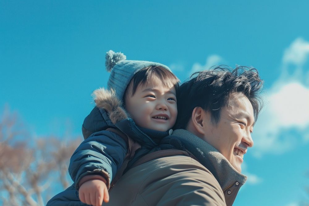 Young asian father carrying son on back hugging person people.