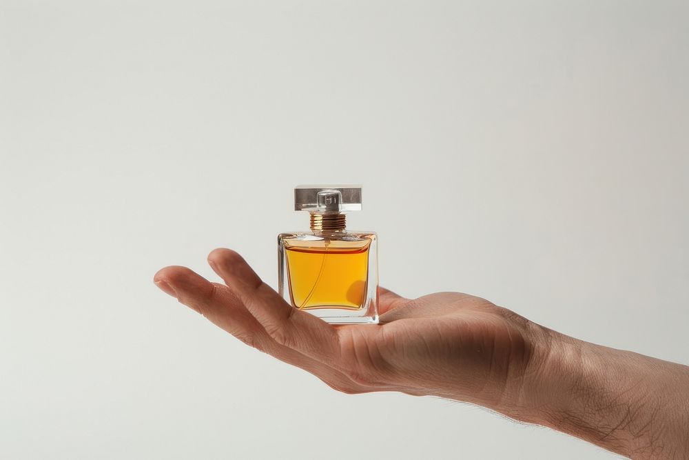 Hand with Small perfume bottle cosmetics.