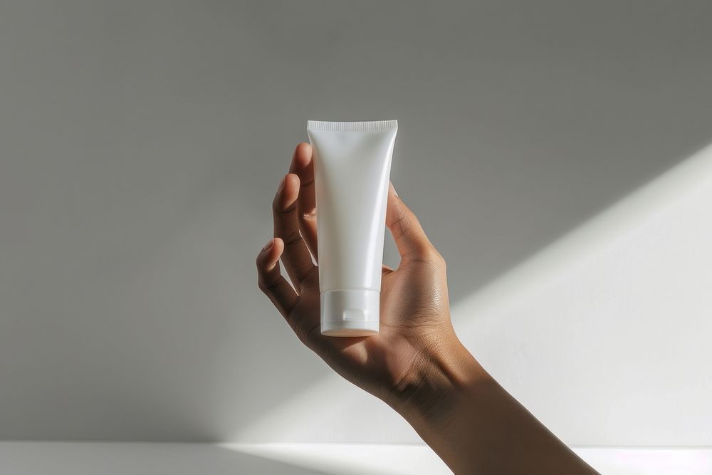 Hand hold transparent cream tube toothpaste cosmetics perfume.