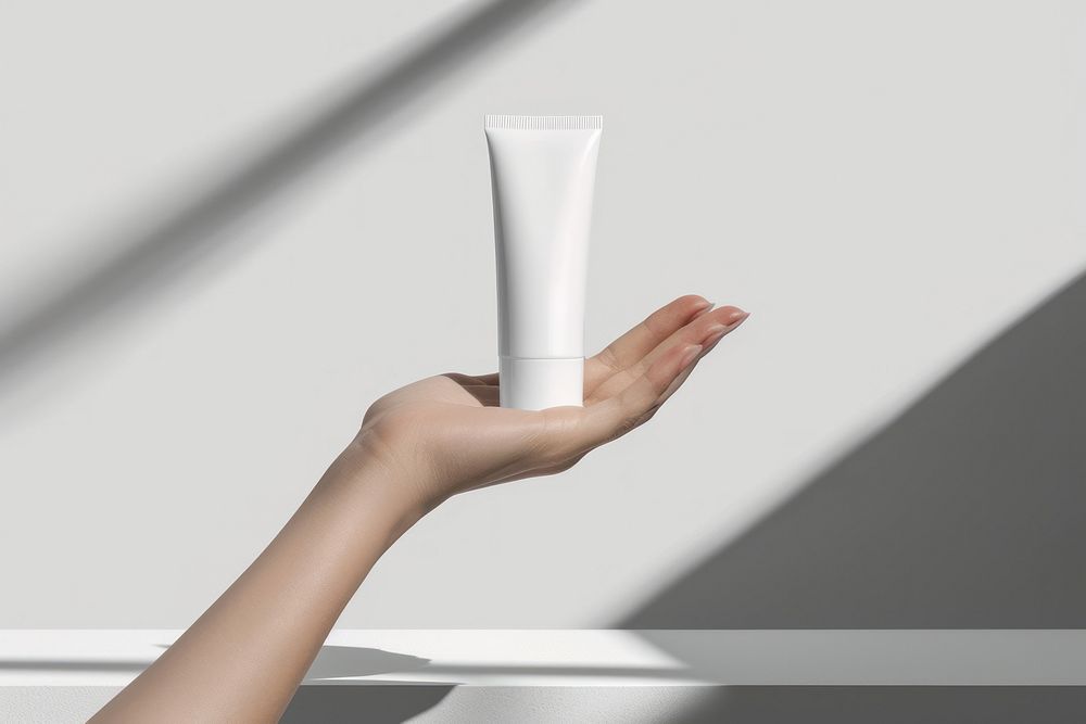 Hand hold white cosmetic tube cosmetics toothpaste beverage.