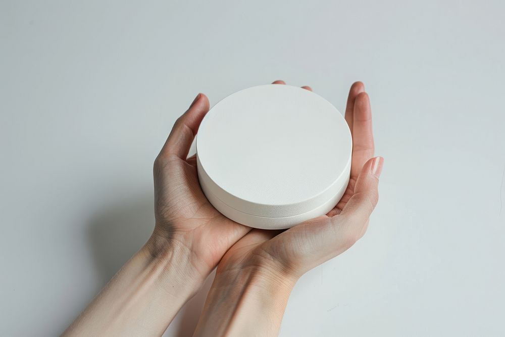 Hand hold white product round shaped box photography porcelain cosmetics.