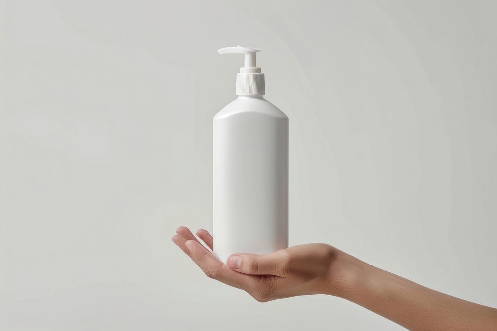 Hand hold white conditioner bottle cylinder lotion shaker.
