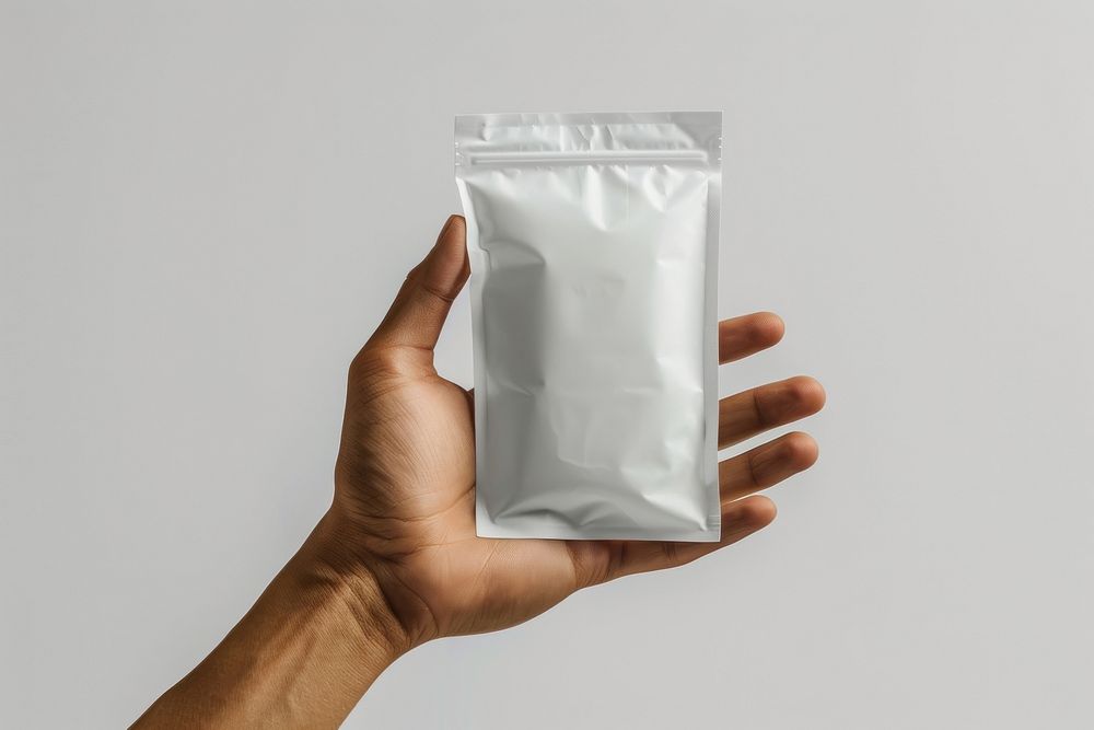 Hand hold white protein powder pouch person human bag.