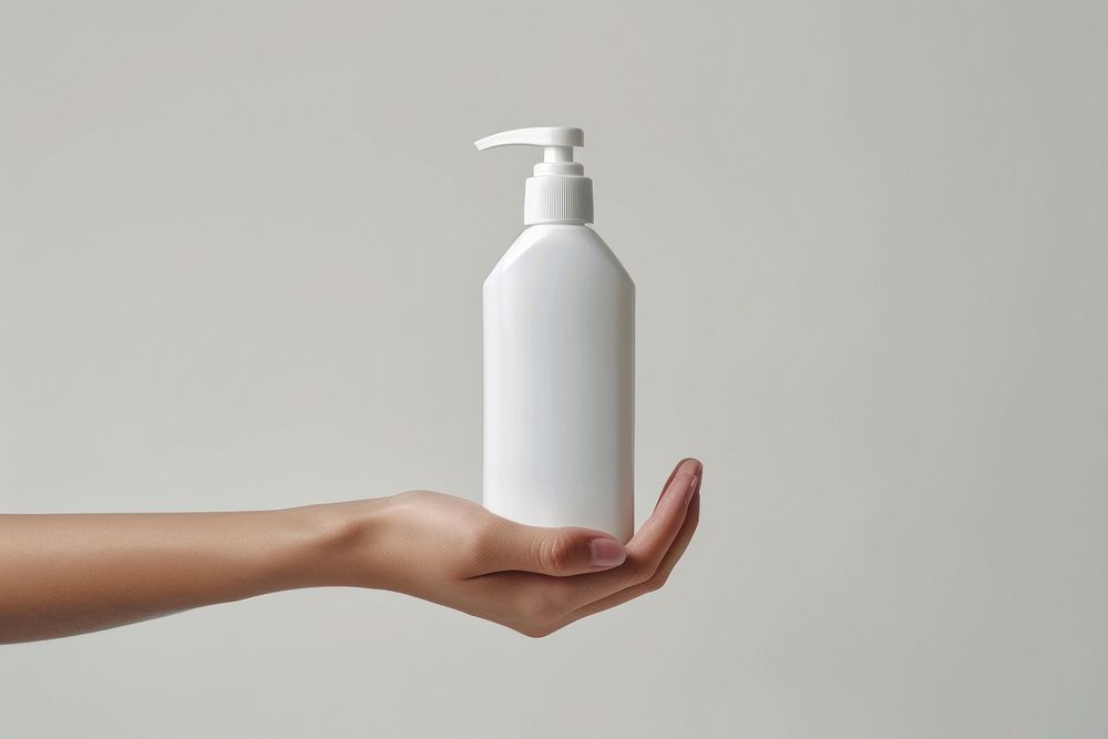 Hand hold white conditioner bottle cylinder lotion shaker.