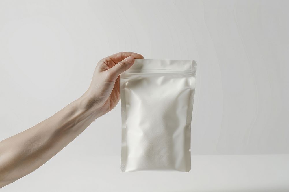 Hand hold white protein powder pouch bag jar.