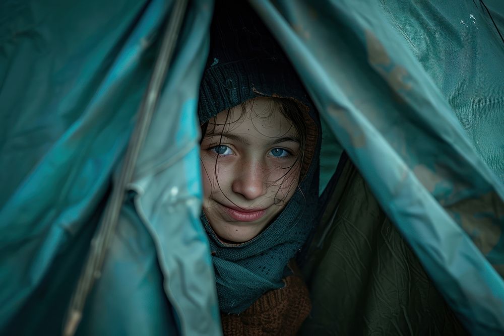 Ukraine refugee stands inside an old tent photography clothing apparel.
