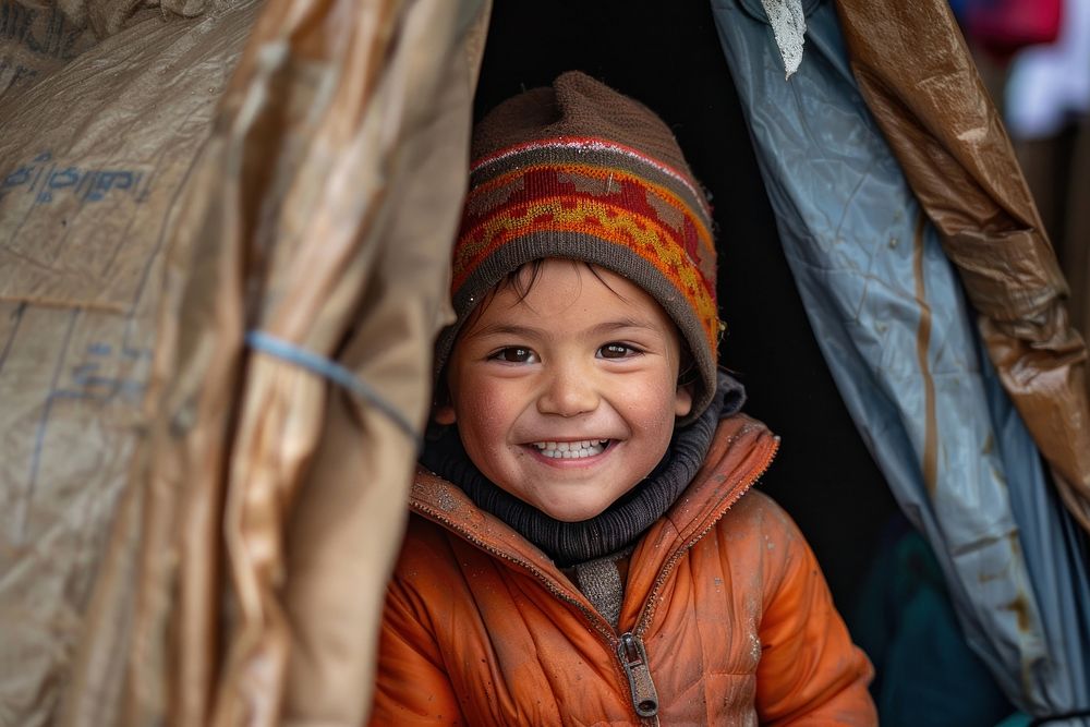 Refugee child stands inside an old tent clothing apparel person.
