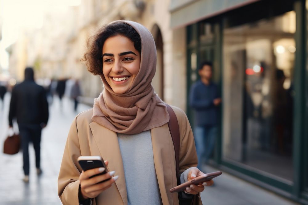 Happy middle east young adult woman holding a visa while he uses a mobile app accessories accessory clothing.