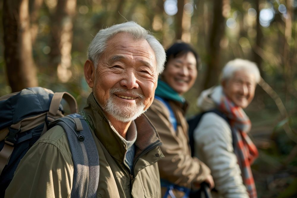 Smiling asian senior man hiking with friends backpack clothing apparel.