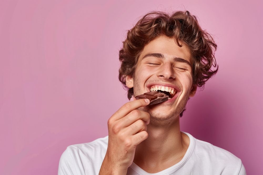 Happy young gay eating chocolate toothbrush person biting.