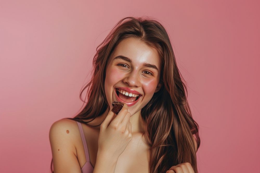 Happy young lady eating chocolate cosmetics laughing lipstick.
