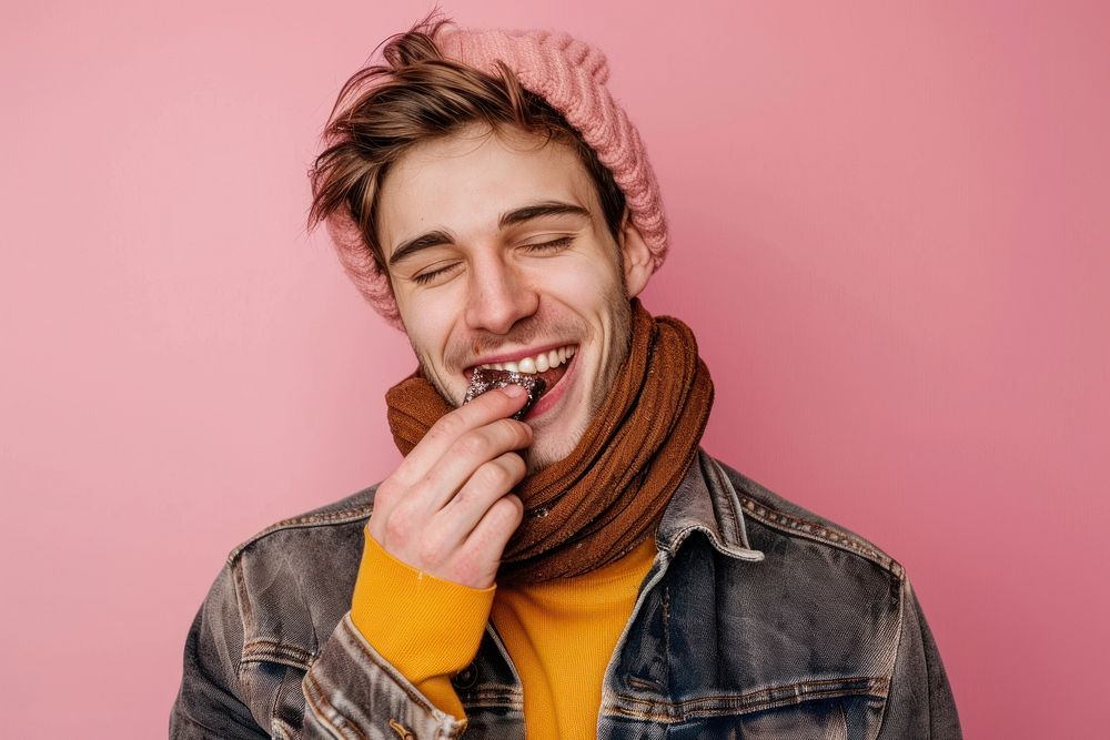 Happy young man eating chocolate clothing apparel biting.