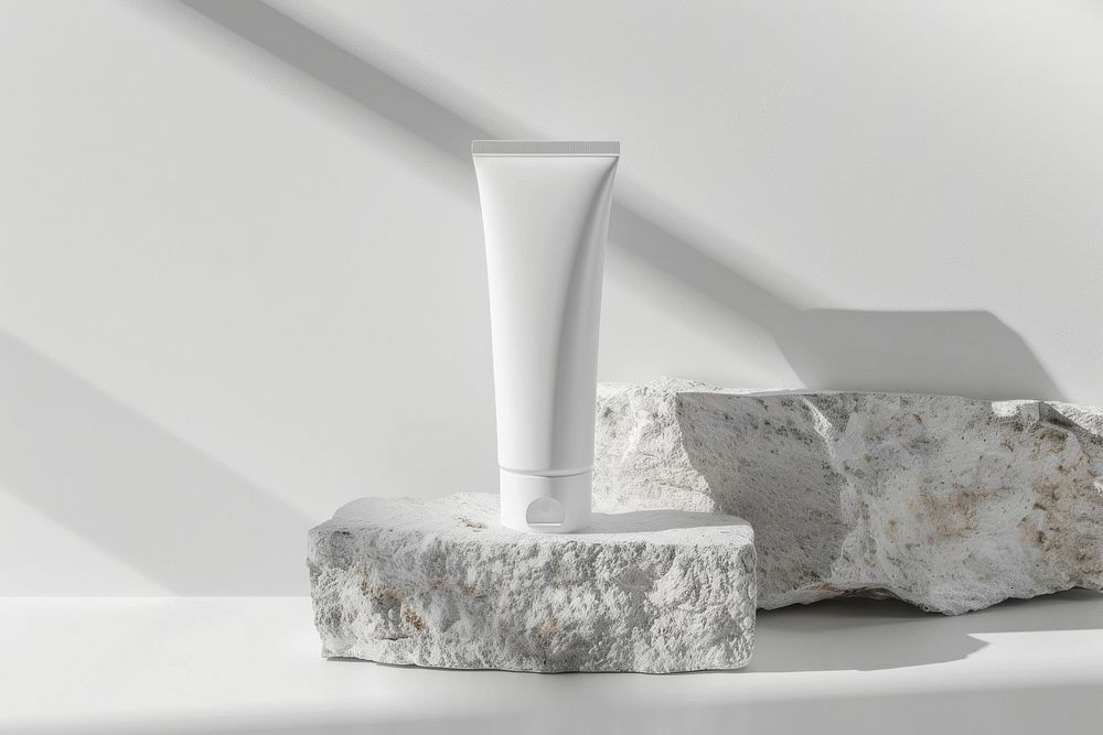 A white tube mockup pottery vase rock.