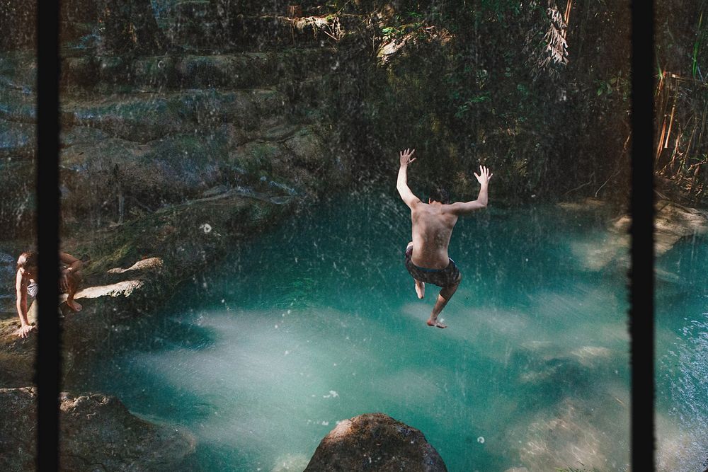 Man jumping into a natural pond