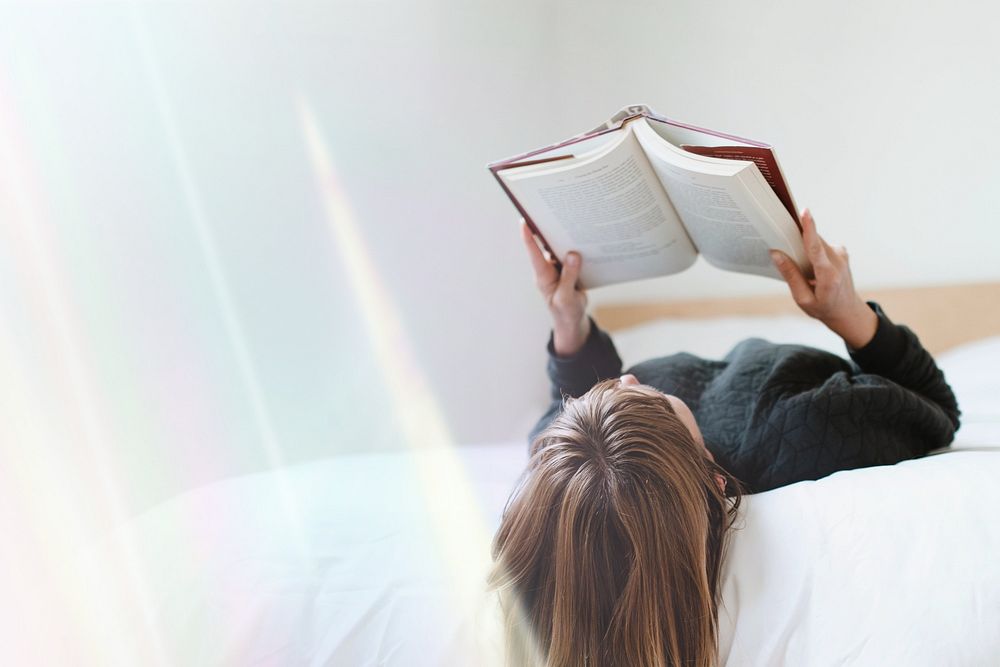 Woman reading a book on her bed during coronavirus quarantine remix