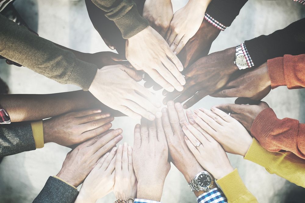 Aerial view of diverse people stacking hands in the middle