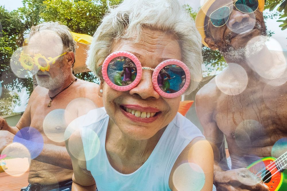 Closeup of diverse senior adults sitting by the pool enjoying summer together