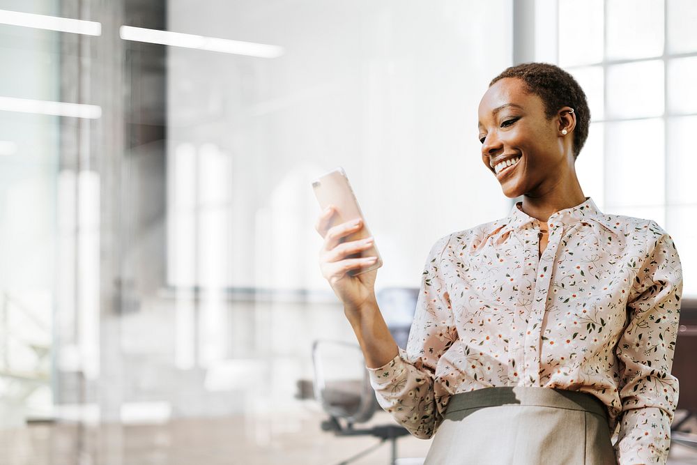 Happy black woman using phone