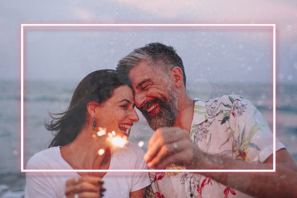 Couple celebrating with sparklers at the beach remix