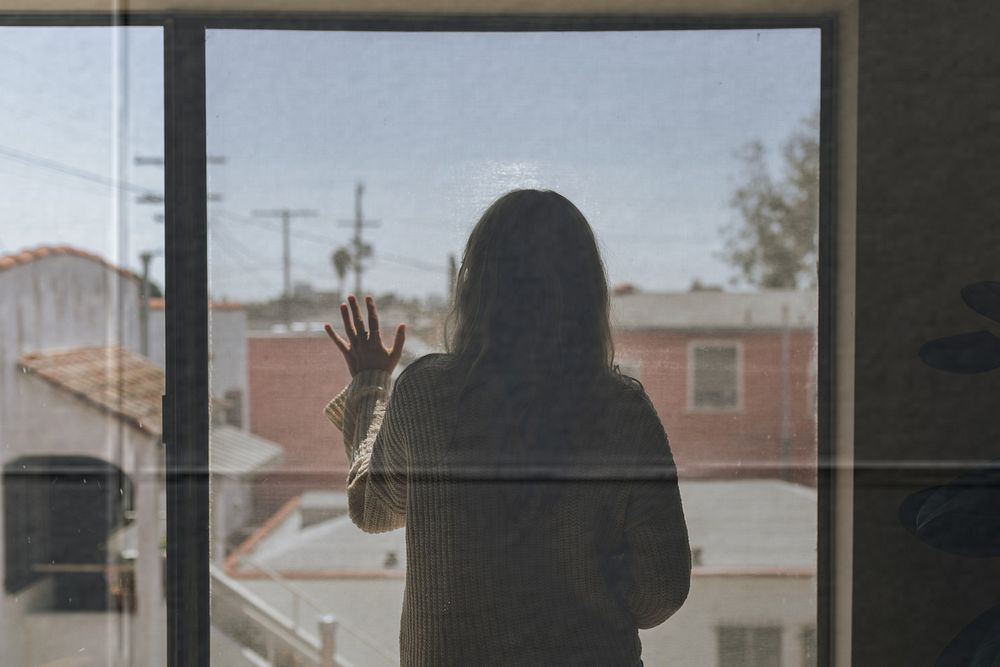 Woman staring out the window during a lockdown