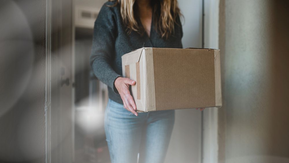 Woman getting her package from the front door during the coronavirus pandemic