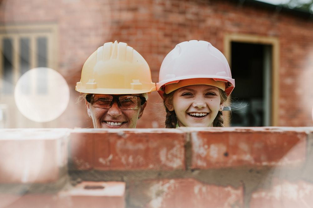 Playful mother and daughter bricklaying