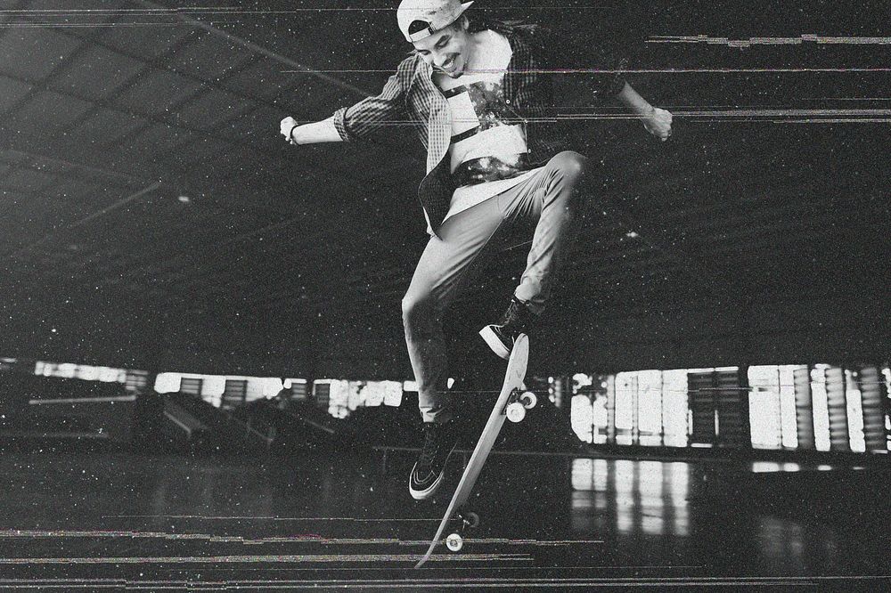 Cheerful man enjoying skateboard grayscale
