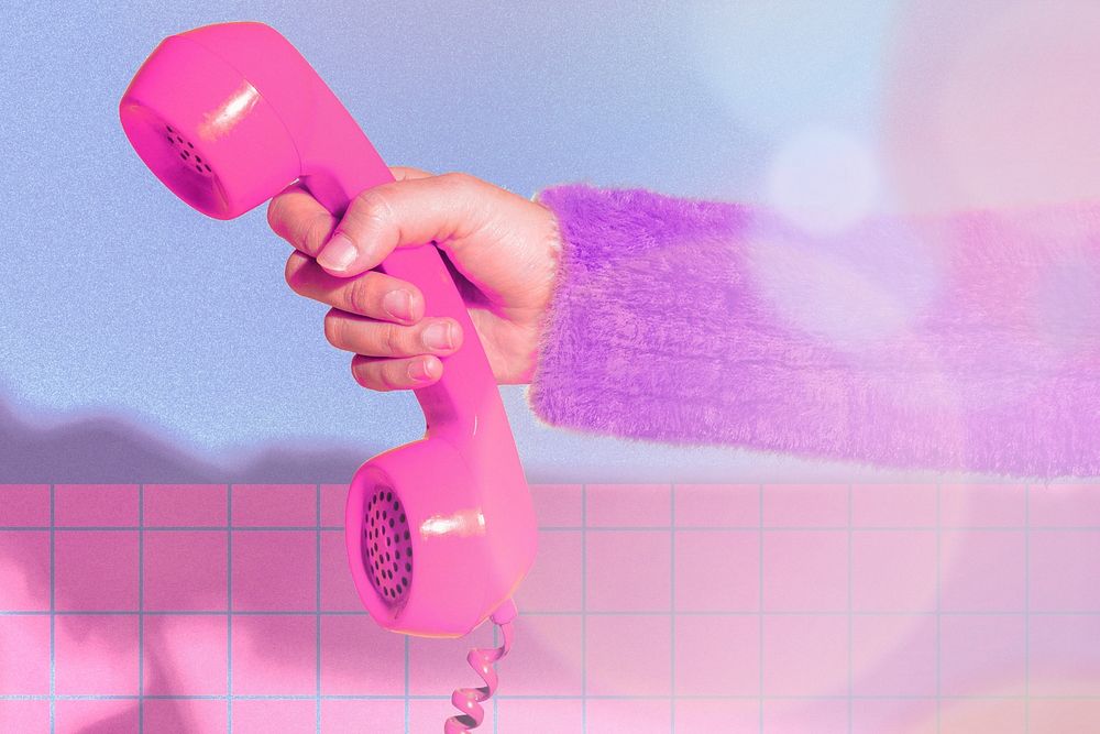 Hand holding pink retro phone, colorful design