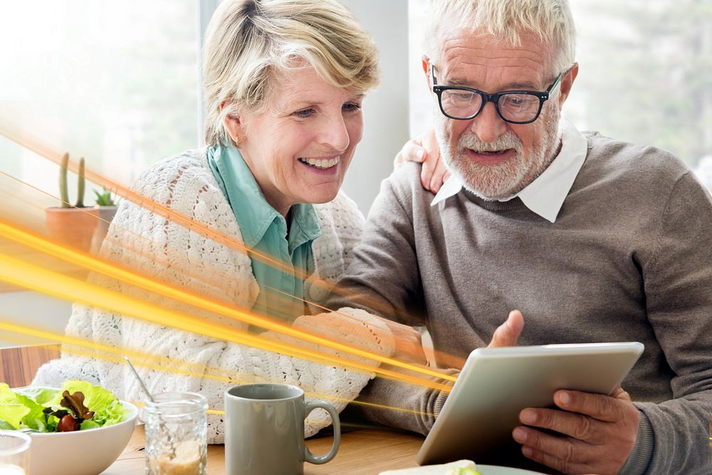 Happy senior couple using tablet remix