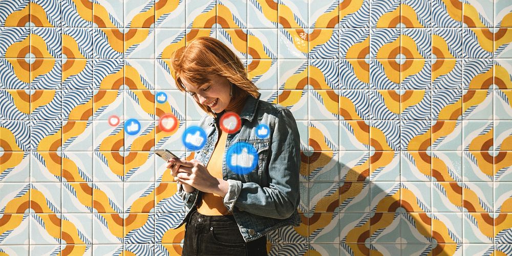 Woman using her phone at a modern patterned wall