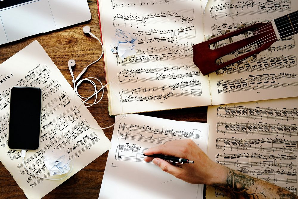 Tattooed man composing musical notes