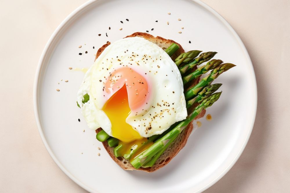 Poached egg on asparagus and avocado toast plate food.