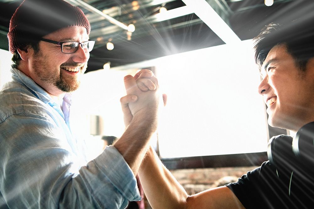 Happy team members holding hands