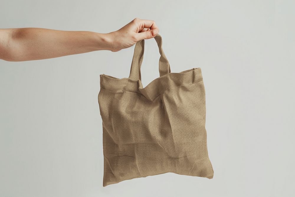 Hand holding brown eco friendly tote bag