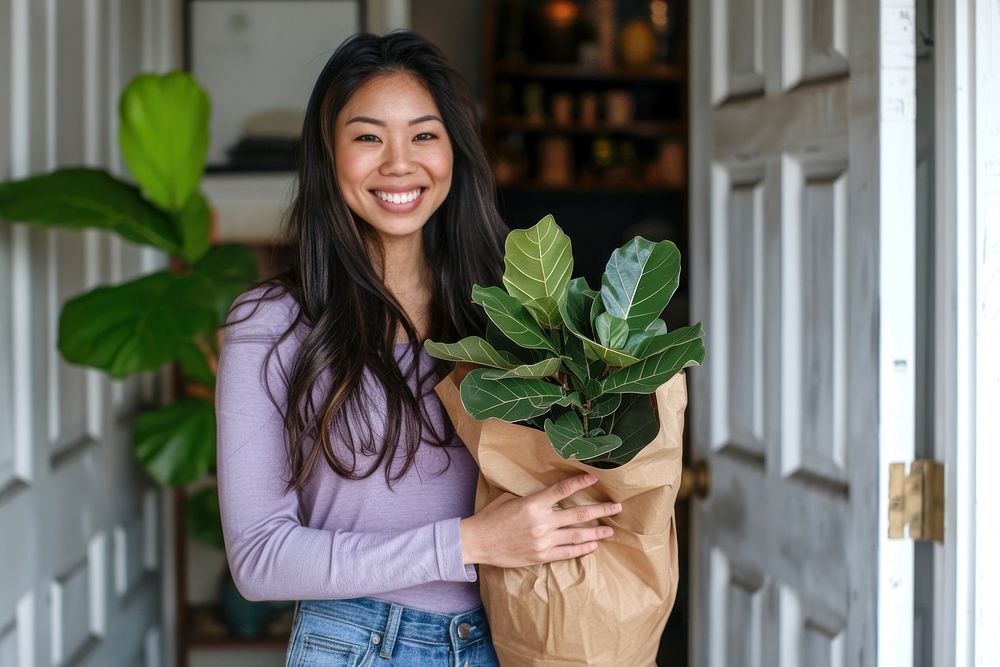 Woman holding potted plant indoors