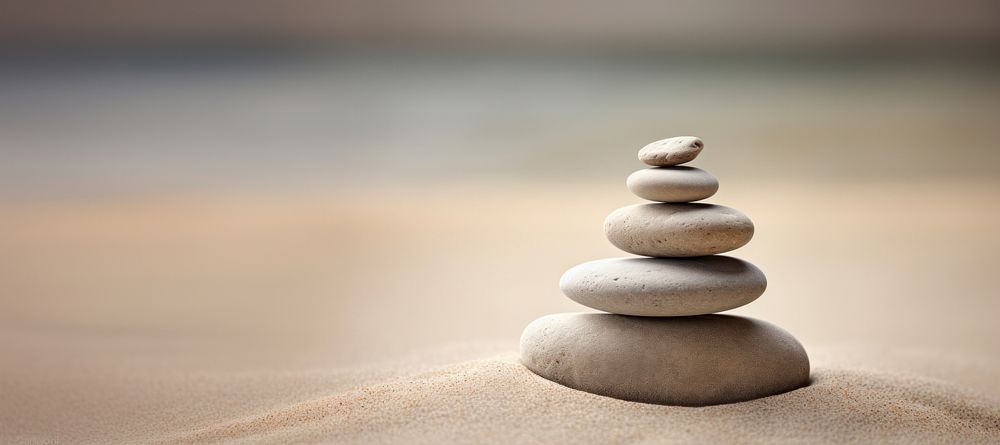 Balanced stones on sandy beach