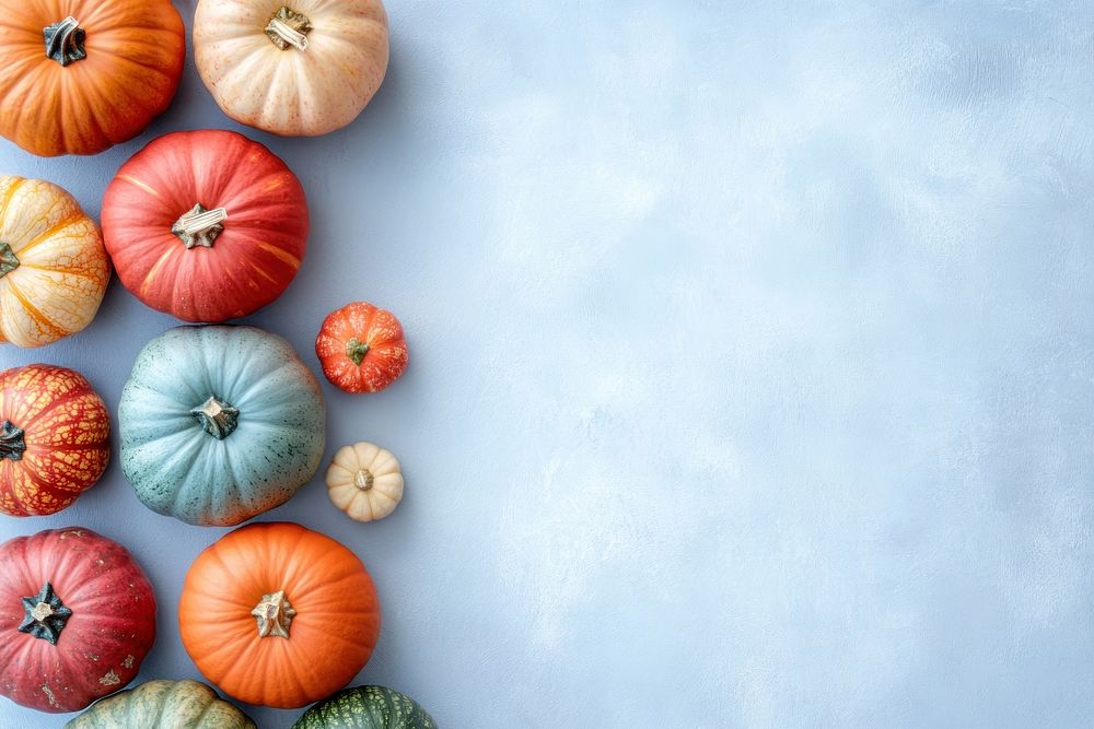 Autumn background with differently colored pumpkins on a light blue table vegetable autumn gourds.