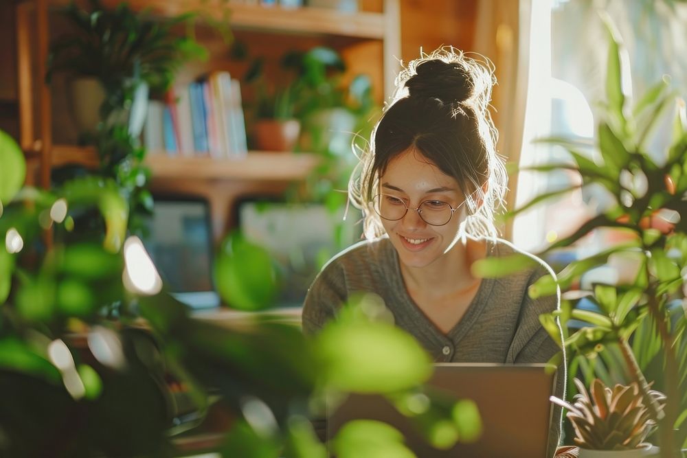 Woman working amidst indoor plants