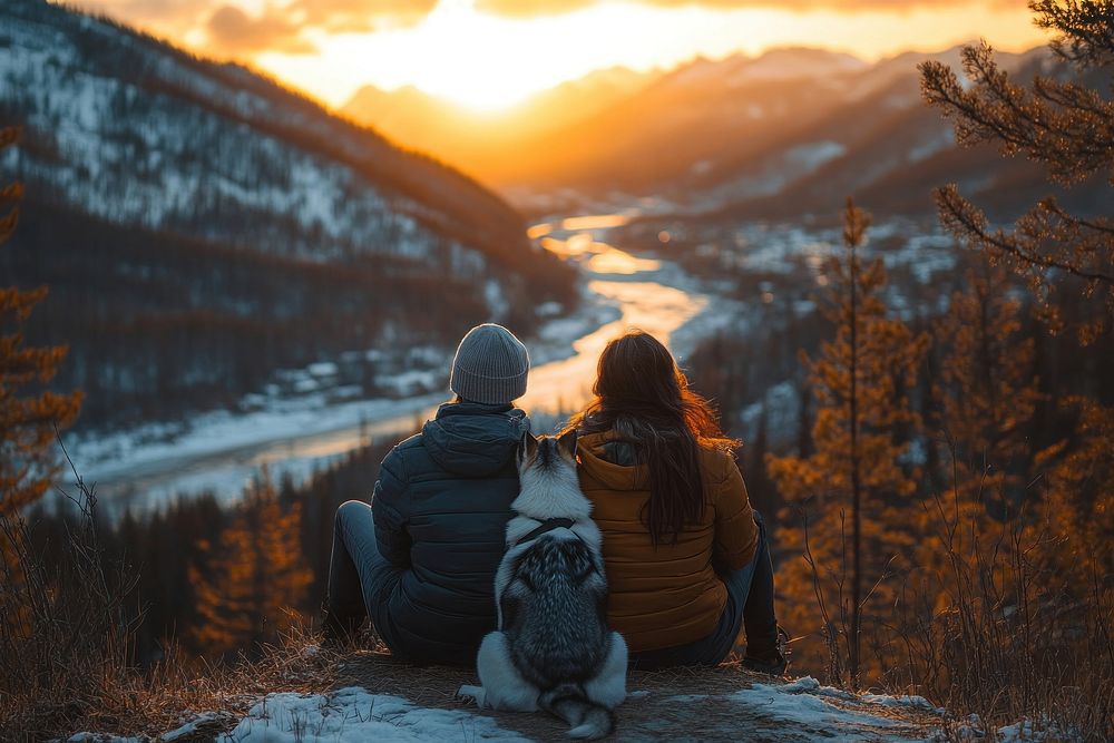 Couple and dog sitting outdoors mountain watching.