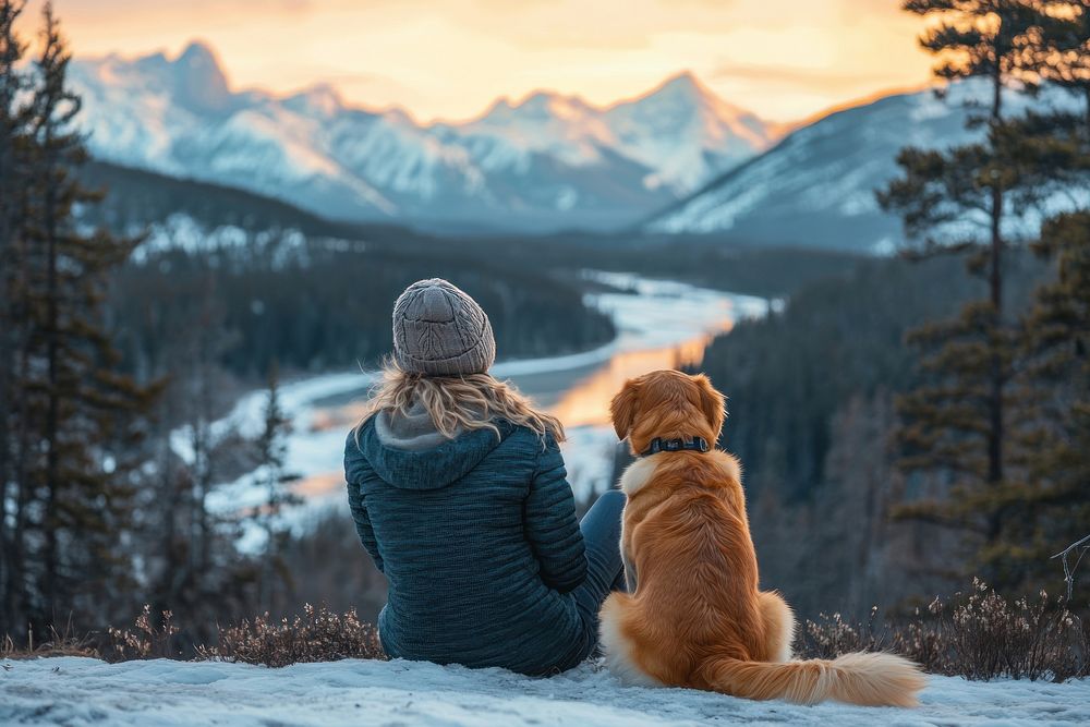 Woman and dog sitting snow outdoors mountain.